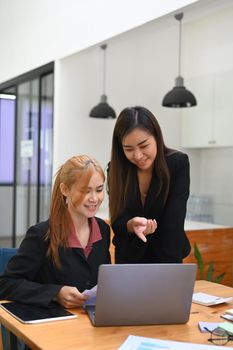 Two young business people discussing project developing financial research, working together in office.