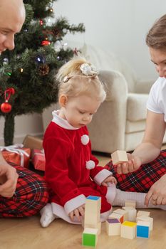 Baby child with hearing aid and cochlear implant having fun with parents in christmas room. Deaf and health