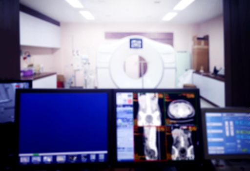 Blurred background of Computed tomography or CT scan room with control workstation and monitors in the hospital.
