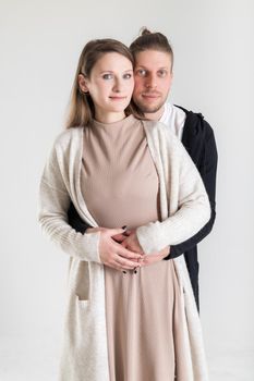 Vertical portrait of a young caucasian couple in love on a white background.