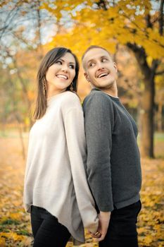 A love story in an interethnic couple in nature on an autumn sunny evening.