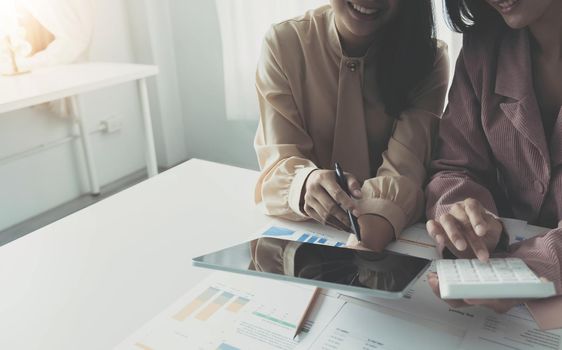 Financial analysts analyze business financial reports on a digital tablet planning investment project during a discussion at a meeting of corporate showing the results of their successful teamwork..