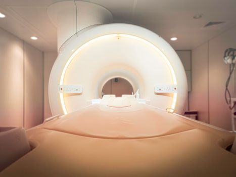 MRI Scanner or Magnetic resonance imaging scanner machine in Hospital isolated on blurred MRI Room background.