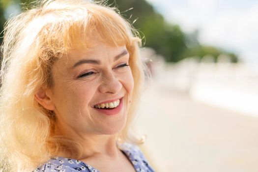 adult woman with wrinkles on her face smiling broadly. middle aged blonde laughing. High quality photo