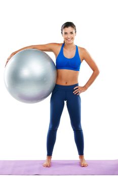 Portrait of a sporty young woman holding an exercise ball against a white background.