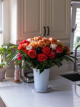 Bouquet of beautiful roses on the marble table in a kitchen.