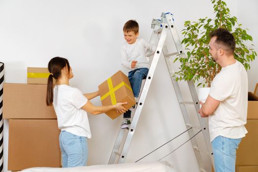 Portrait of happy family with cardboard boxes in new house at moving day, close up