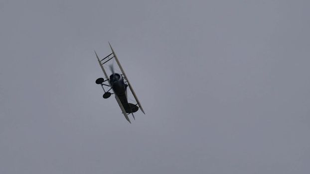 Zeltweg, Austria SEPTEMBER, 6, 2019 Vintage biplane of First World War WWI in grey heavy rain cloudy sky. FVM CVM O1 Tummelisa propeller plane of Swedish Air Force. Copy space.
