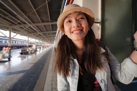 Happy Asian woman travel by traditional train in Thailand
