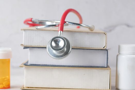 stethoscope on a stack of books on table ,