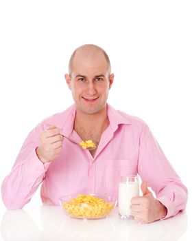 Young man eating very healthy breakfast consisting of corn flakes and milk. Isolated on white.