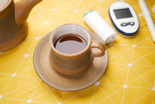 Close up of diabetic measurement tools and green tea on yellow background .