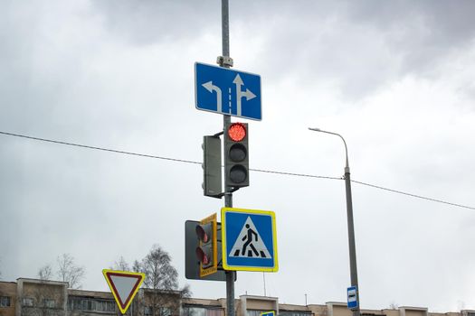 Red signal traffic light on blue sky background close up