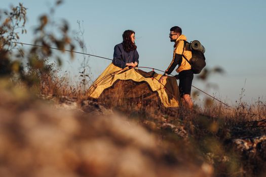 Two Young Travelers Make Tent During Sunset to Spend Night on Top of Hill