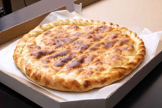 Ruddy Ossetian closed pie in the box close up