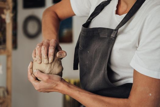 Unrecognisable Female Potter Master Preparing Pile of Clay to Creating Pot on Pottery Wheel in Her Ceramic Studio