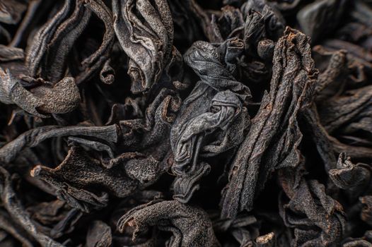 Dry black tea leaves close up. Macro background of tea production.