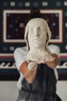 Female Potter Artist Holding in From of Face a Handmade Crafted Head of Human, Art Work
