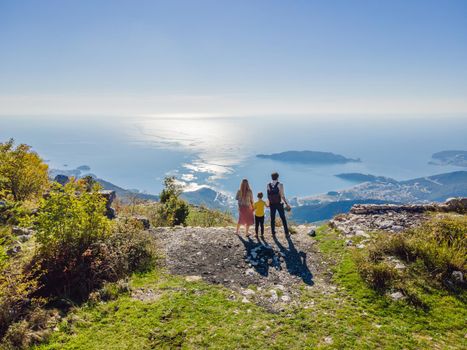 Happy family on the background of Panoramic view of the city of Budva, Montenegro. Beautiful view from the mountains to the Adriatic Sea.