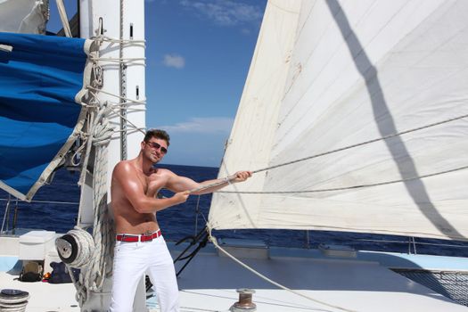 Man enjoying summer time holiday on sailing boat.