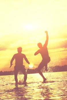 Group of young people playing games on sandy beach on a summer day.