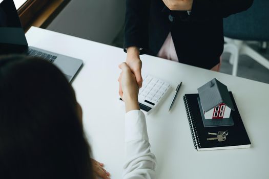 Guarantees, Mortgages, Signings, Insurance, contract, agreement concept, Real Estate Agents are shaking hands with customers to congratulate them after landing a deal.