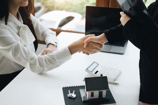 Guarantees, Mortgages, Signings, Insurance, contract, agreement concept, Real Estate Agents are shaking hands with customers to congratulate them after landing a deal.