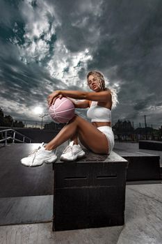 Portrait of a beautiful and sexy girl with a basketball in studio