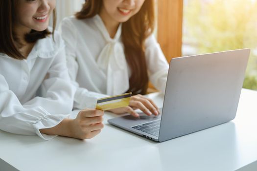 Online Shopping and Internet Payments, Beautiful Asian women are using their credit cards and computer laptop to shop online or conduct errands in the digital world.