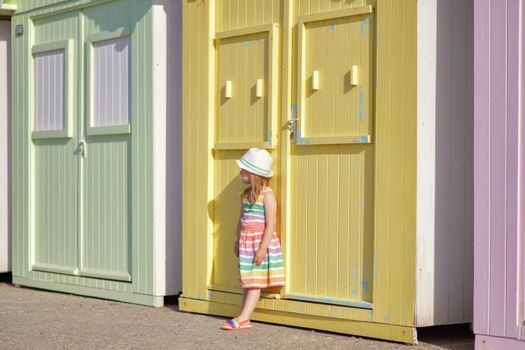 Girl in a colored dress near wooden houses on the ocean Saint aubin sur mer