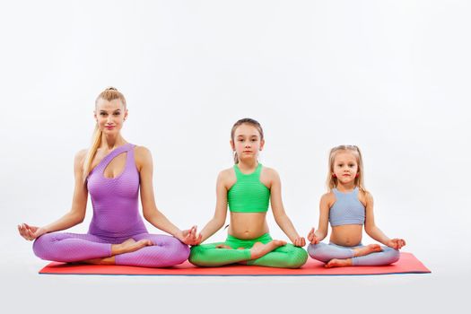 Girls and Instructor or mother doing gymnastic exercises in fitness class