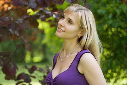 Portrait of a young smiling woman walking in the park.