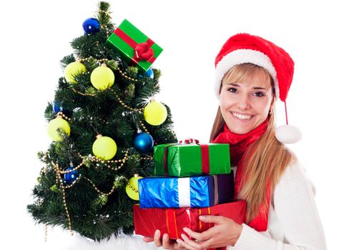 Beautiful young woman with gifts next to christmas tree, isolated on white background.