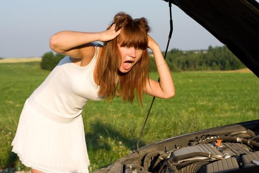 young woman bent over car engine