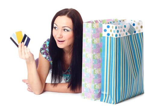 Beautiful surprised woman holding credit cards and bags. Isolated on white.