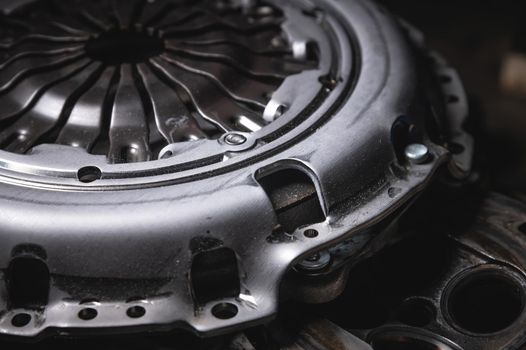 Close-up clutch disc of a car lies on metal parts contrast shot.