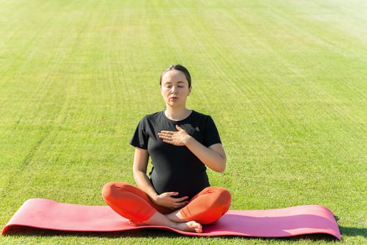 pregnant woman performs yoga asanas. High quality photo