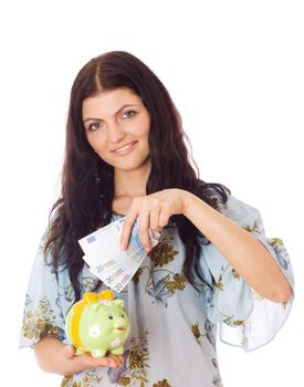 Woman holding piggybank and putting money in it, isolated on white.