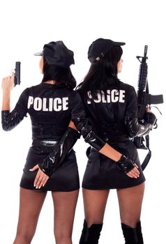 Portret of two beautiful sexy policewomen with handcuffs in a black uniform that aiming a submachine gun. Iisolated on white.