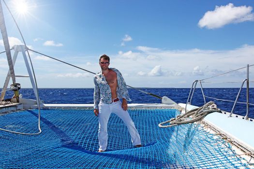 Man enjoying summer time holiday on sailing boat.