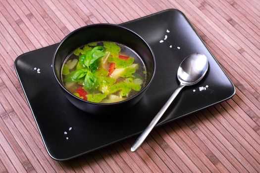 Tuscan vegetable soup with basil pesto in black plate