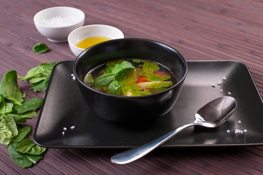 Tuscan vegetable soup with basil pesto in black plate
