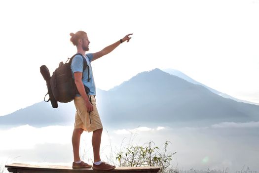 Hiker man with backpack travel on top volcano Batur, Indonesia