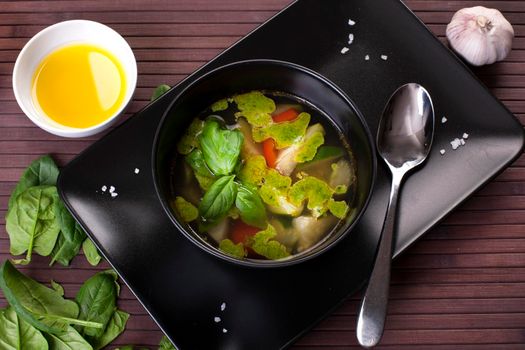 Tuscan vegetable soup with basil pesto in black plate