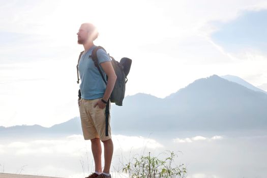 Hiker man with backpack travel on top volcano Batur, Indonesia