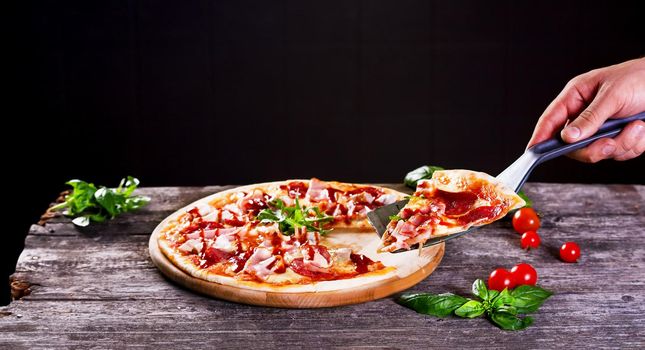 Delicious fresh Pizza with bacon and tomato paste on the wooden background. Top view.