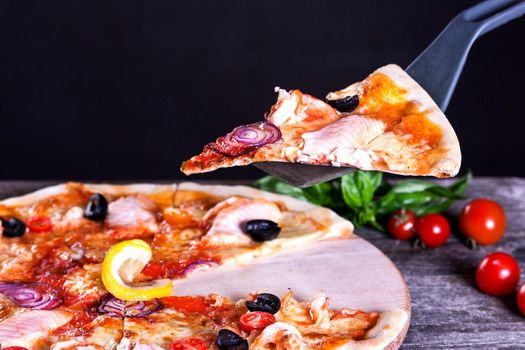 Delicious fresh Pizza with red fish and mozzarella on the wooden background. Top view.