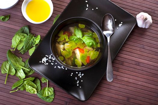 Tuscan vegetable soup with basil pesto in black plate