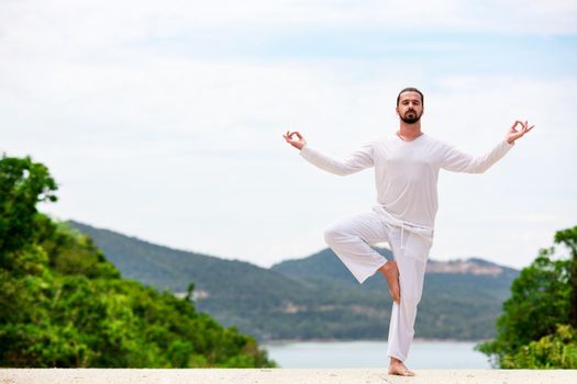 Man Doing Indian classic art Yoga at the Sea and Mountains