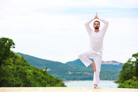 Man Doing Indian classic art Yoga at the Sea and Mountains